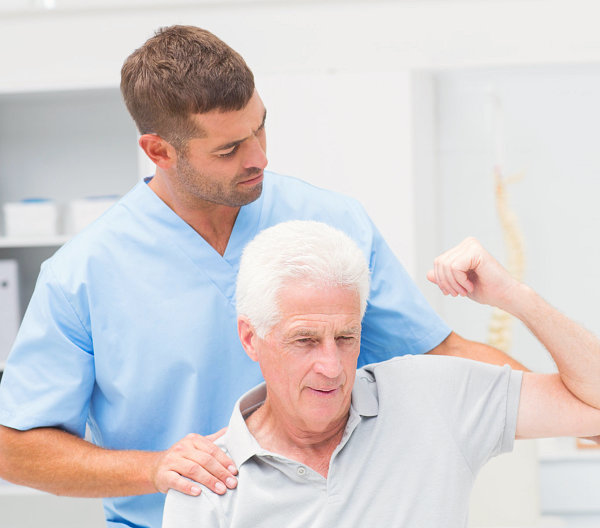 caregiver assisting patient in lifting his arm